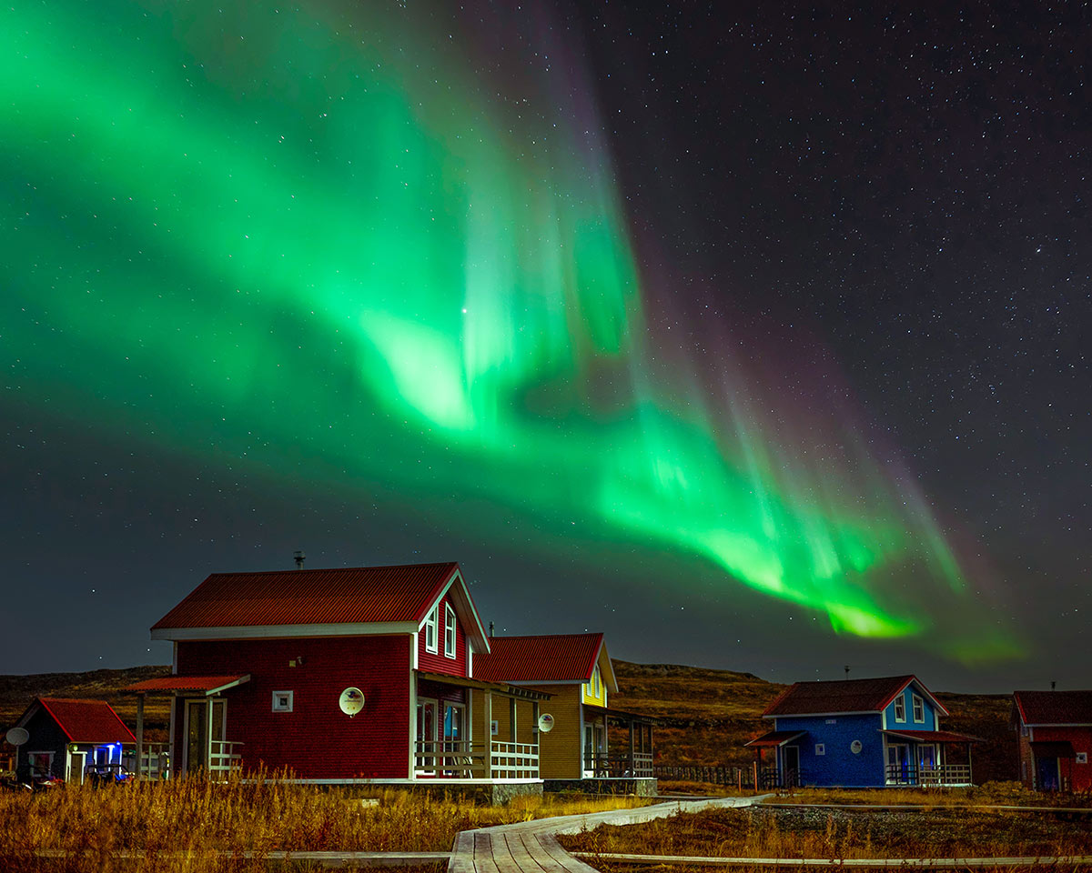 Северное сияние над коттеджами Tundra House на Кольском полуострове